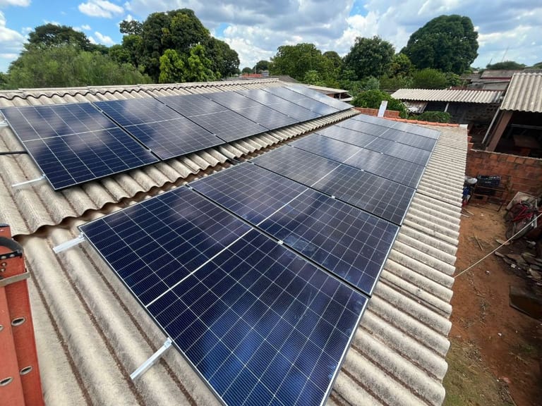 16 painéis solares instalados sobre telhado de fibrocimento, residência em Dourados-MS, com a escada da equipe encostada no canto do telhado